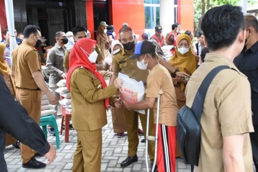 Walikota Eva Dwiana memberikan beras dari Baznas Kota Bandarlampung kepada salah seorang warga.